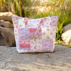 a pink and white bag sitting on top of a rock