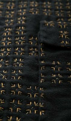 an embroidered black cloth with gold crosses on the back and sides is seen in close up