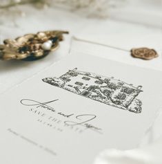 a close up of a wedding card on a table with other items in the background