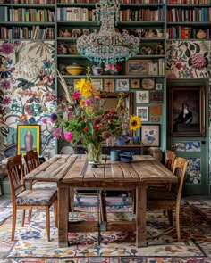 a dining room table surrounded by bookshelves and flowers