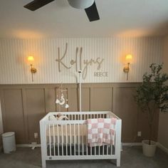 a white crib in a room with striped walls