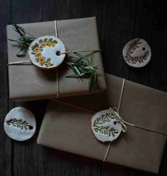 three wrapped presents are sitting on top of brown wrapping paper and tied with twine