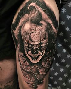 a man's leg with a tattoo on it and an image of a clown