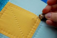 someone is stitching on the side of a piece of fabric