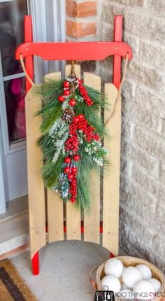 a wooden sled with a christmas wreath on it and eggs in a basket next to it