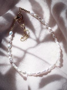 This beaded anklet features a collection of tiny white freshwater pearls to capture the enticement of Hawaii’s white sand beaches. Wear this gold pearl anklet alone or stacked for a classically elegant allure. ✦ DETAILS ✦✧ Name: Maile (MIE-leh) - vine.✧ Adjustable Length up to 10" Inches.✧ White 2-3mm Freshwater Pearls.✧ 14kt Gold Filled Components, Extender, and Clasp.✧ All Ke Aloha Jewelry pieces come packaged thoughtfully, beautifully, and ready for gift giving. Tiny Beads Pearl Bracelet, Gold Pearl Anklet With Pearl Charm, Elegant Adjustable Pearl Anklets, Elegant Pearl Anklets With Pearl Chain, Elegant Pearl Drop Anklets As Gift, Elegant Pearl Chain Anklets, Elegant Pearl Beaded Anklets, White Pearl Anklets For Summer, White Pearl Bracelet With Tiny Beads For Wedding