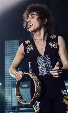 a man holding a large metal object on top of a stage