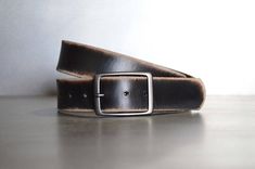 We take pride in making belts.  We use the highest quality leather to deliver an outstanding product that will last decades.  All of our Leather Belts are cut from FULL GRAIN, 9 oz., Veg tanned Double shoulders.  Our Vintage belts are distressed and antiqued to give each piece a unique finish.  These belts have a snap enclosure, so changing out buckles is simple and quick.  We also make our leather belts with 7 holes for optimum sizing for a sure fit.  Belts are 1.5" wide.Sizing is easy.  Simply Everyday Black Leather Belt Buckles, Everyday Black Leather Belt Buckle, Black Leather Belt Buckles As Gift, Classic Leather Belt Buckles As Gift, Classic Leather Belt Buckles For Gifts, Black Rectangular Leather Belt Buckles, Rugged Leather Belt Buckles, Rugged Leather Belt Buckles With Strap, Black Leather Rectangular Belt Buckles