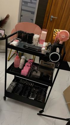 a table with cosmetics and makeup products on it next to a pink chair in a room