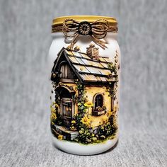 a ceramic jar with a house painted on it