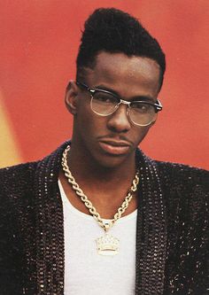 a man wearing glasses and a chain around his neck