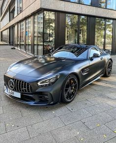 a black mercedes sports car parked in front of a building