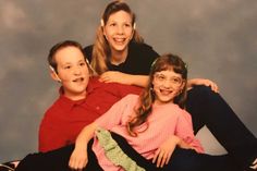 three children sitting on the floor with their arms around each other and smiling at the camera