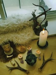 a table topped with antlers and candles next to a window