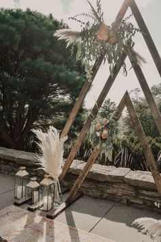 an outdoor wedding setup with candles, flowers and feathers