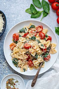 an image of a plate of pasta with tomatoes and spinach on the side text reads tomato spinach pasta easy simple delicious