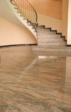 an empty room with marble floors and stairs