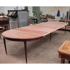 a wooden table sitting on top of a floor next to other tables in a room