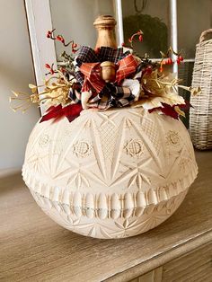 a white vase sitting on top of a wooden table