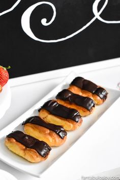 chocolate covered doughnuts and strawberries on white plates