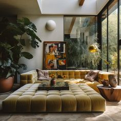 a living room filled with furniture next to a large glass window and potted plant