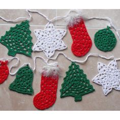 crocheted christmas stockings and stocking decorations on a tile floor with white string