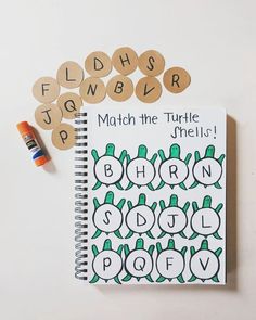 a notebook with the words match the turtle shells on it next to some crayons