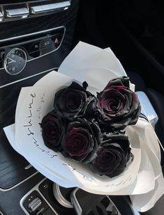 a bunch of roses sitting on top of a white plate in the center of a car