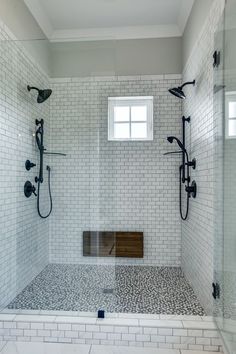 a walk in shower sitting next to a white tiled wall and floor with two windows