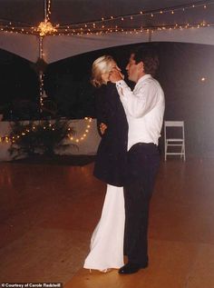 a bride and groom dance together on the dance floor at their wedding reception with string lights in the background