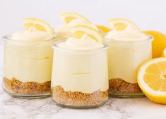 lemon cheesecake in small glass jars with sliced lemons around the edges and on top