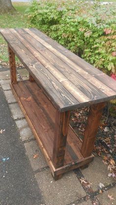 a wooden bench sitting on top of a sidewalk