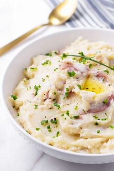 a white bowl filled with mashed potatoes and ham