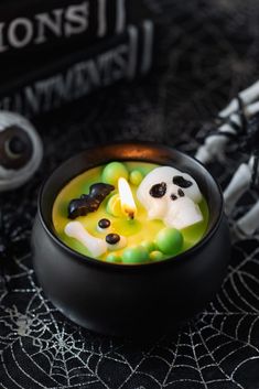 a black bowl filled with candy and halloween decorations