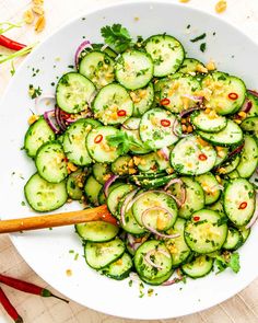 a white bowl filled with cucumbers and onions