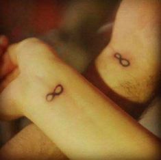 two people with tattoos on their arms, one is holding the other's arm