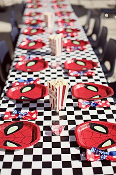 the table is decorated with spiderman plates and cups