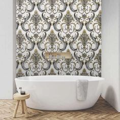 a bath tub sitting next to a wall with an ornate pattern on the back side