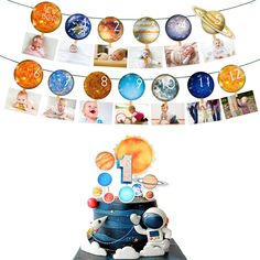 a birthday cake with pictures of the planets hanging from it's sides and an astronaut on top