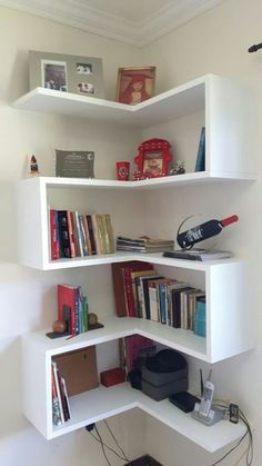 a corner book shelf with books and other items on it