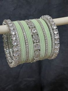 a stack of bracelets sitting on top of a wooden stick