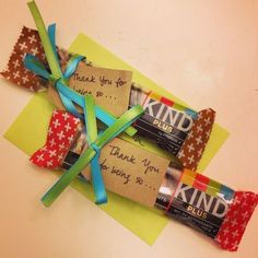 three candy bars wrapped in brown paper with blue ribbon and thank you for being served