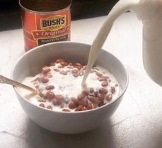 milk being poured into a bowl of cereal