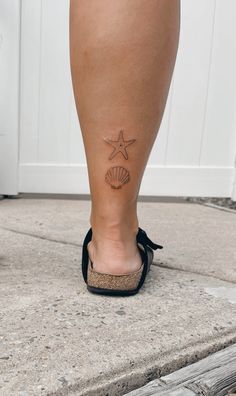 a woman's foot with a starfish tattoo on her left leg and a seashell in the middle