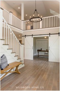 an open floor plan with stairs leading up to the second story and a bench in front of it