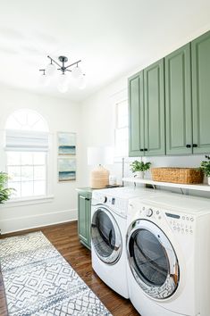 a washer and dryer in a room with green cabinets