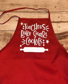 a red apron that says teachers bake smart cookies on the front, and an image of a rolling pin in the back