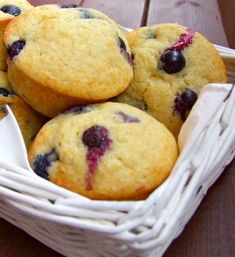 a basket filled with blueberry muffins on top of a wooden table