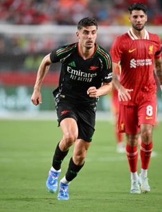 two soccer players are running on the field