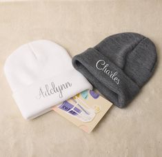 two personalized beanies sitting next to each other